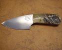 This is a three finger/palm knife with a handle of rams horn. The blade is high carbon tool steel, notice the transition (harmon) line. The rams head is etched into the blade